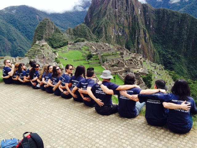 Ayuda volunteers seated in a row at Machu Picchu, Peru