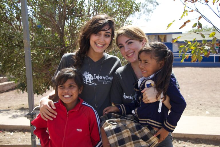 Young volunteers with children at an Ayuda event