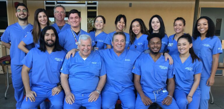 Ayuda volunteers in blue scrubs smiling together