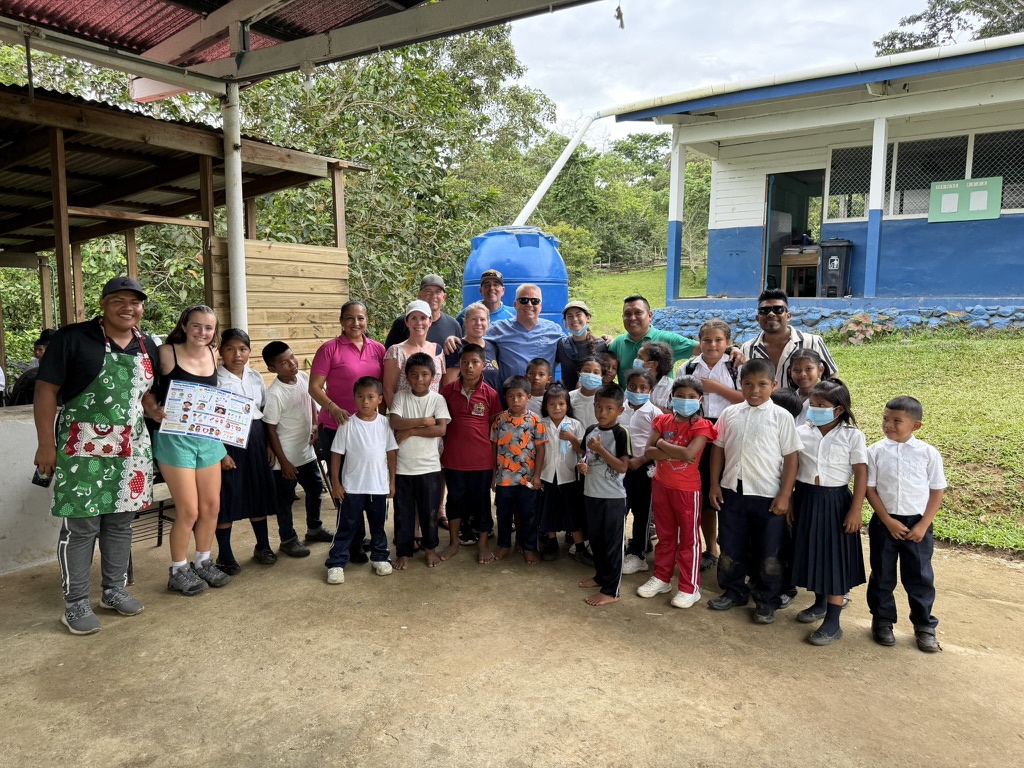 Rotarians, volunteers, teachers and schoolchildren in white shirts gathered in front of the Bocatorito school in Bocas del Toro
