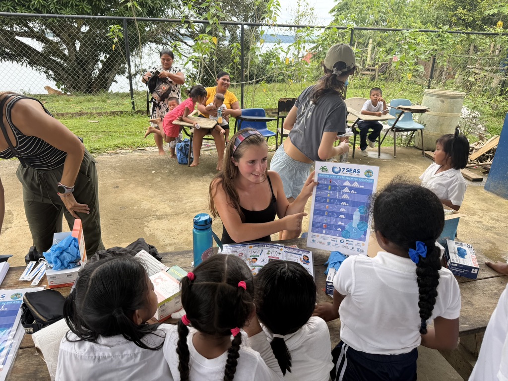 Sophia D'Angelo showing schoolchildren a poster of how much sugar is in their drinks